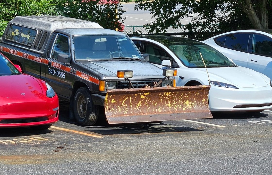 Close view of rusted Meyers plow blade mounted on the front of the Dodge D50
